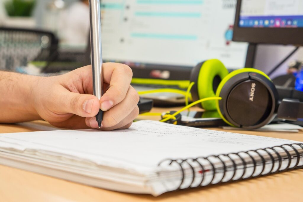 A focused young student practicing effective study habits at a clean desk with a notebook and laptop.